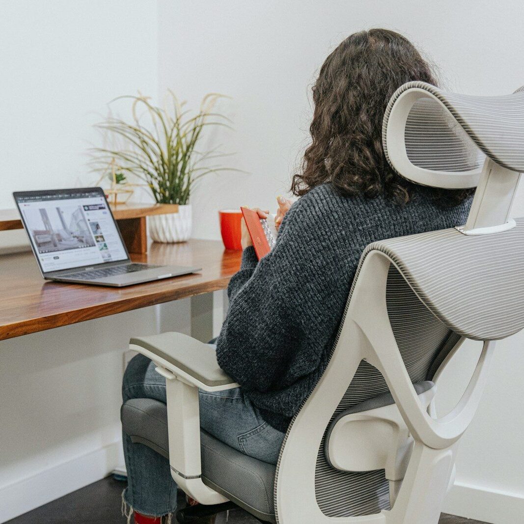 a woman sitting at a desk with a laptop